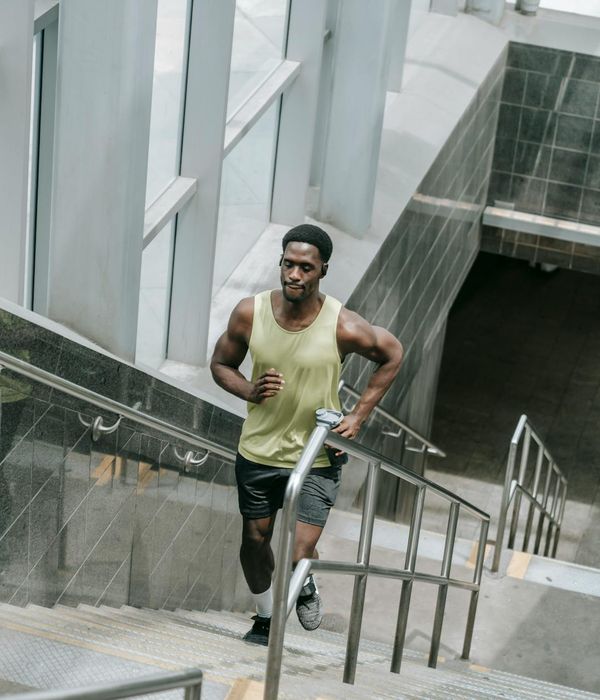 Man performing a controlled strength exercise in a bright gym.